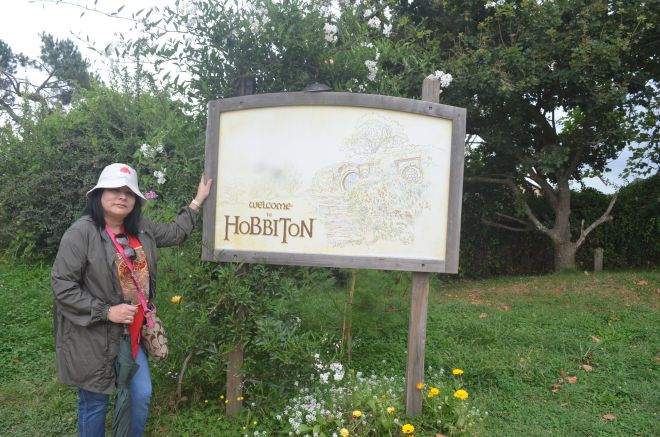 The guide gathering the group & the Welcome to Hobbiton sign.